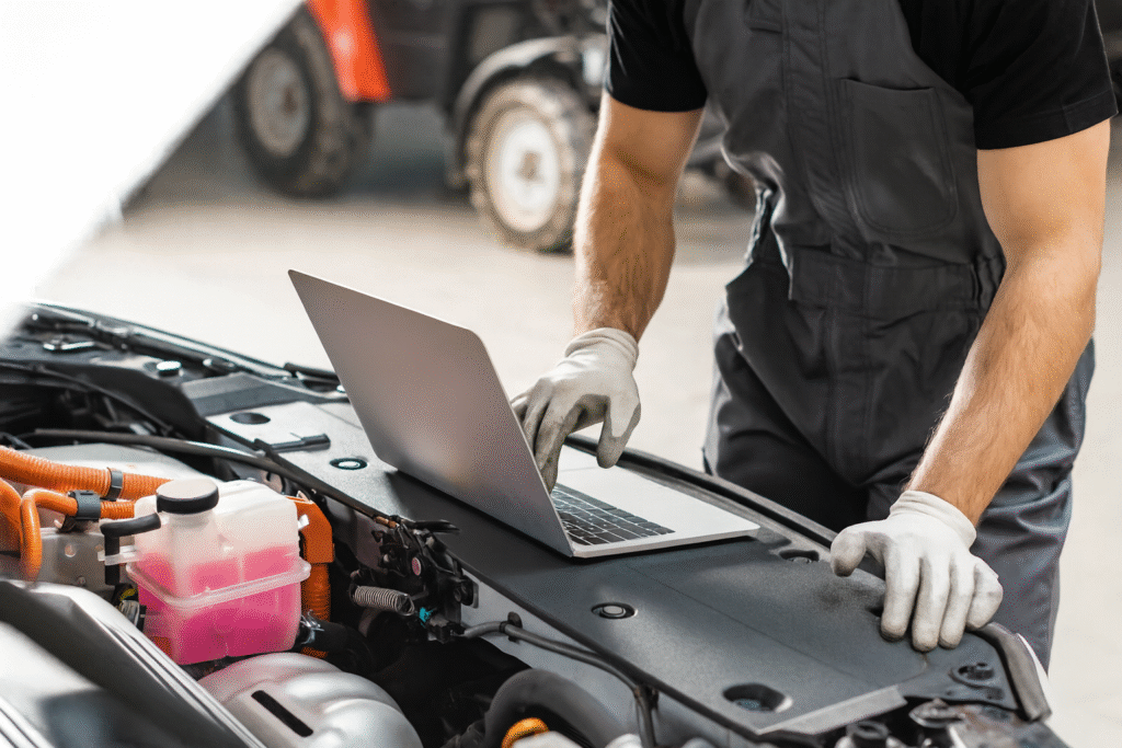 mechanic, laptop on car engine
